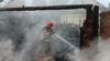 In this handout photograph taken and released by the Ukrainian Emergency Service on June 5, 2025 a rescuer extinguishes a fire following a drone strike in Pryluky, Chernihiv region, amid the Russian invasion of Ukraine.